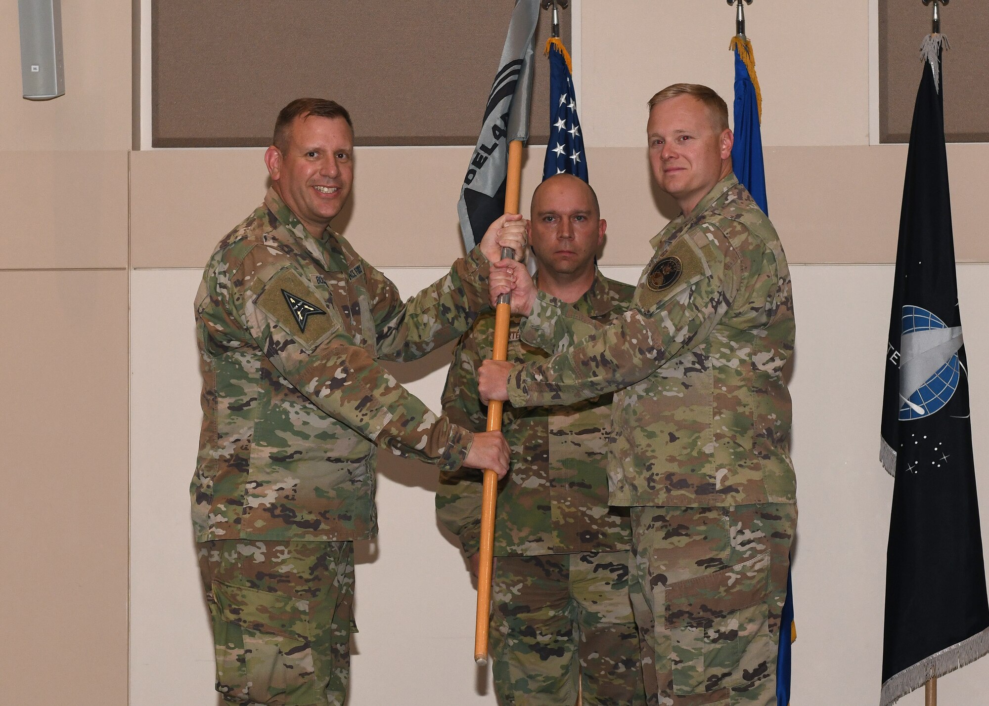 Maj. Luke Basham, incoming Space Delta 4, Detachment 1 commander, receives the guidon from Col. Richard Bourquin, DEL 4 commander, during a change of command ceremony at Buckley Space Force Base, Colo., June 24, 2021. The passing of the guidon is a military tradition that symbolizes a transfer of command and commemorates past leadership and success of the outgoing commander. (U.S. Space Force photo by Airman 1st Class Haley N. Blevins)