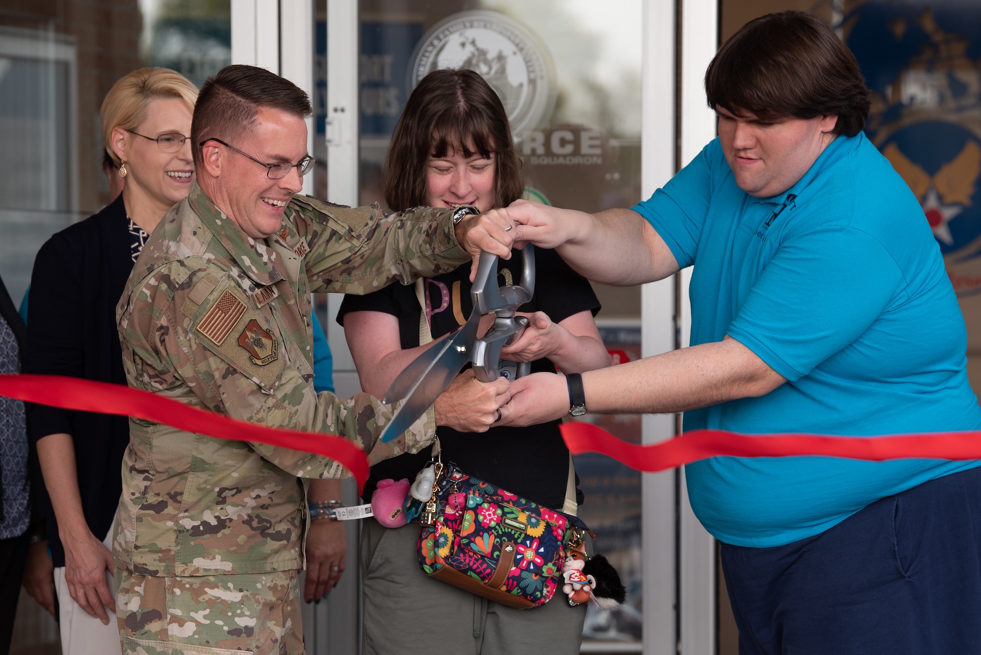 U.S. Air Force Col. J. Scot Heathman, 375th Air Mobility Wing commander, Jimmy Howe, and Heather McKenney, Exceptional Family Member Program members, cut the ribbon signifying the completion of the renovation of the EFMP One Stop on Scott Air Force Base, Illinois, June 24, 2021. The Airman & Family Readiness Center at Scott AFB brought together components of the EFMP One Stop to serve the families at Scott. (U.S. Air Force photo by Airman 1st Class Stephanie Henry)