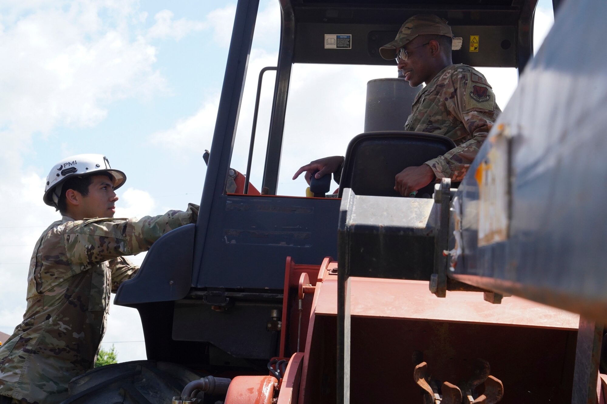 U.S. Air Force Senior Airman David Mirnada and Khari Harris, 85th Engineering Installation cable and antenna installers, check a tractor at Keesler Air Force Base, Mississippi, June 23, 2021. The 85th EIS is the only active duty command, control, communication-computer engineering and installation squadron in the Air Force. (U.S. Air Force photo by Senior Airman Spencer Tobler)