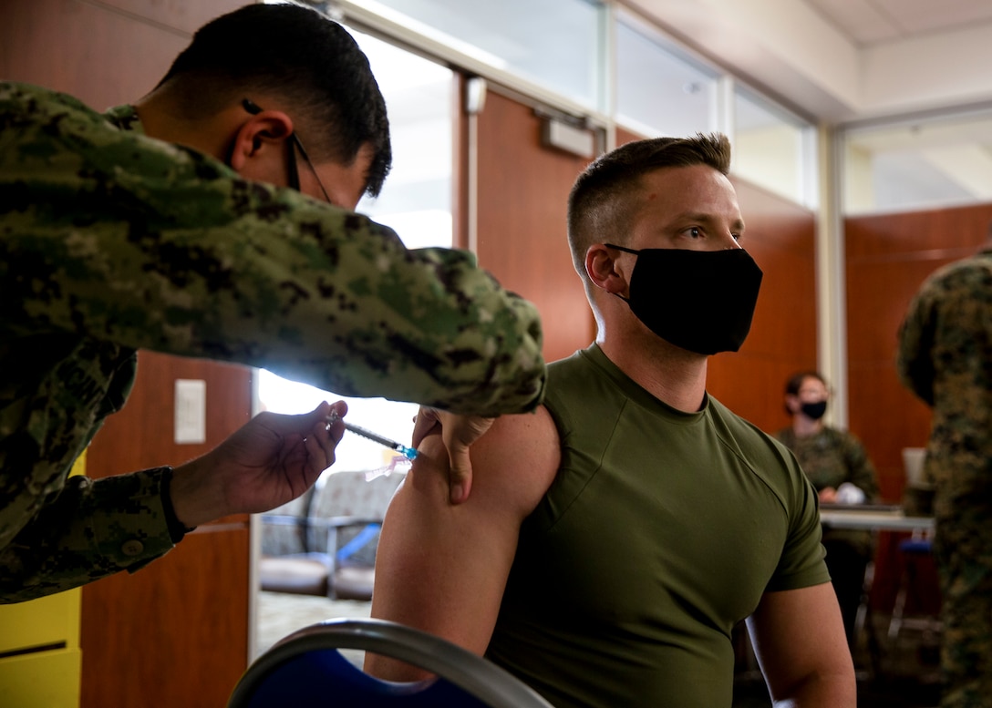 U.S. Marine Capt. Michael Cathey, the aide-de-camp for the commanding general of Marine Corps Installations West, Marine Corps Base Camp Pendleton, receives the COVID-19 vaccine at the naval hospital on Camp Pendleton, California, Jan. 12, 2021. While the COVID-19 vaccination is voluntary, all beneficiaries and Marine Corps personnel are strongly encouraged to be vaccinated to protect their health and their community. Vaccines are being administered in a phased approach, prioritizing healthcare workers and first responders, as well as mission critical and deploying personnel. Vaccination distribution prioritization within DOD, and the Marine Corps, will be consistent with data-driven CDC guidance for national prioritization. Marines will continue to wear appropriate masks, practice social distancing, regularly wash their hands, and follow restriction of movement guidelines to maintain the safety of others as a large portion of the population will need to be vaccinated before COVID-19 risks diminish. (U.S. Marine Corps photo by Sgt. Jeremy Laboy)