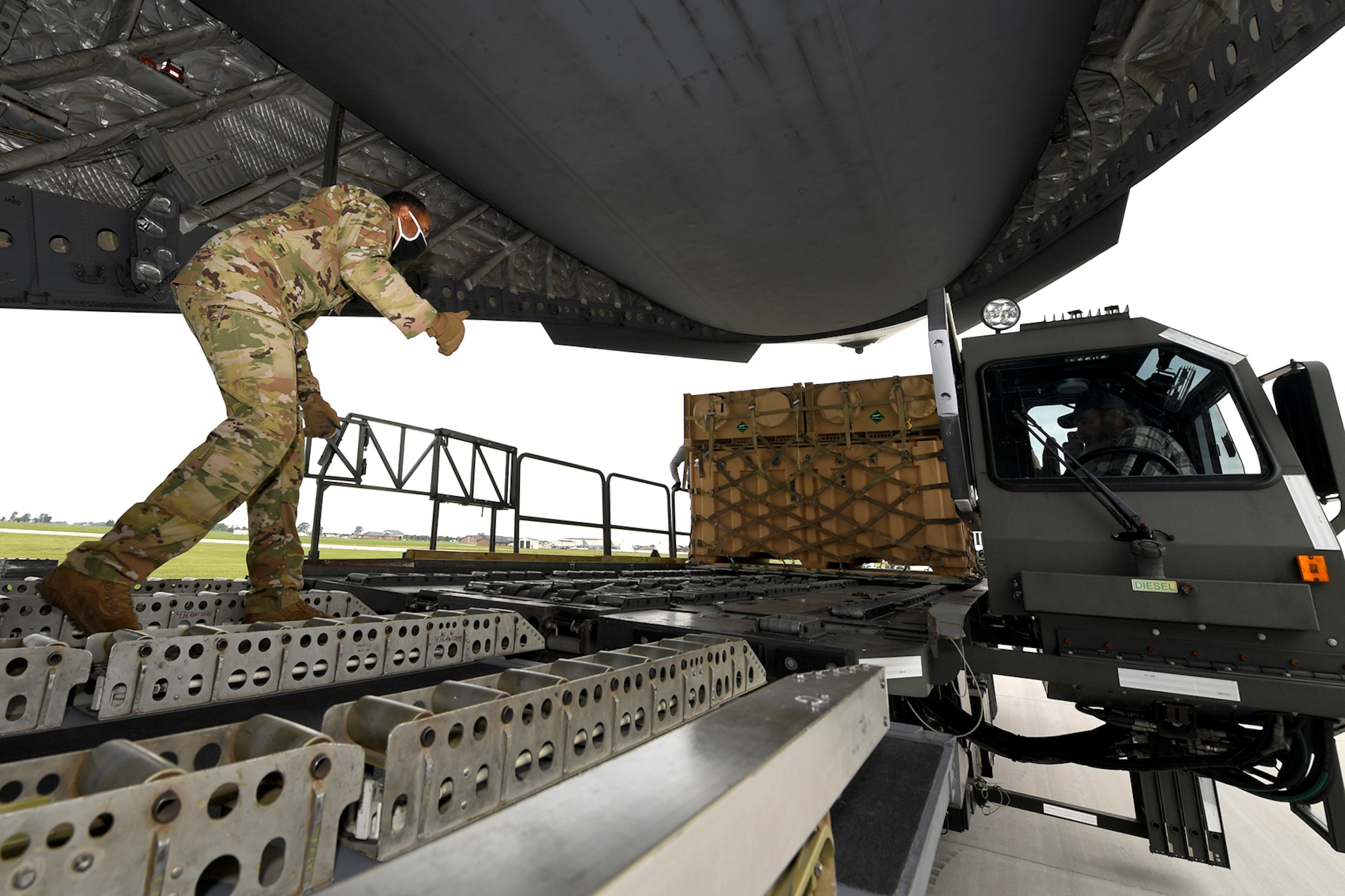 A loadmaster with the 512th Airlift Wing at Dover Air Force Base, Del., directs cargo onto a C-17 Globemaster III, at Grissom Air Reserve Base, Ind., June 1, 2021. Members of Det. 1, 622nd Contingency Equipment Group, Dobbins Air Reserve Base, Ga., palletized and prepared the cargo for shipment to Hawaii to support a joint service exercise called Pacific Warriorz 2021.  (U.S. Air Force photo/Staff Sgt. Chris Massey)