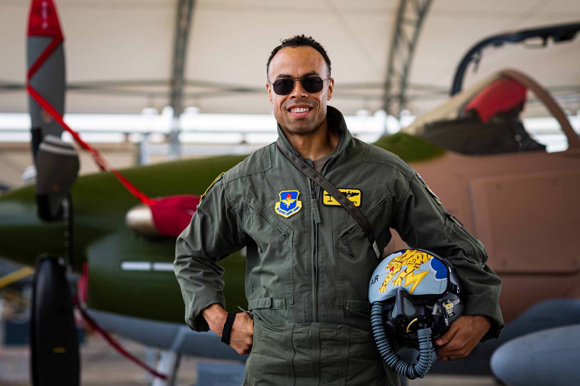 A photo of an Airman posing in front of an aircraft