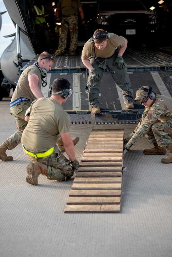 Aerial porters from the Kentucky Air National Guard’s 123rd Contingency Response Group prepare to offload cargo from an aircraft at Volk Field, Wis., June 11, 2021, as part of a Joint Task Force-Port Opening supporting Operation Lone Oak. The aircraft, from the Alaska Air National Guard, delivered trucks, supplies and personnel who were taking part in the Patriot North 21 exercise here. (U.S. Air National Guard photo by Senior Master Sgt. Vicky Spesard)