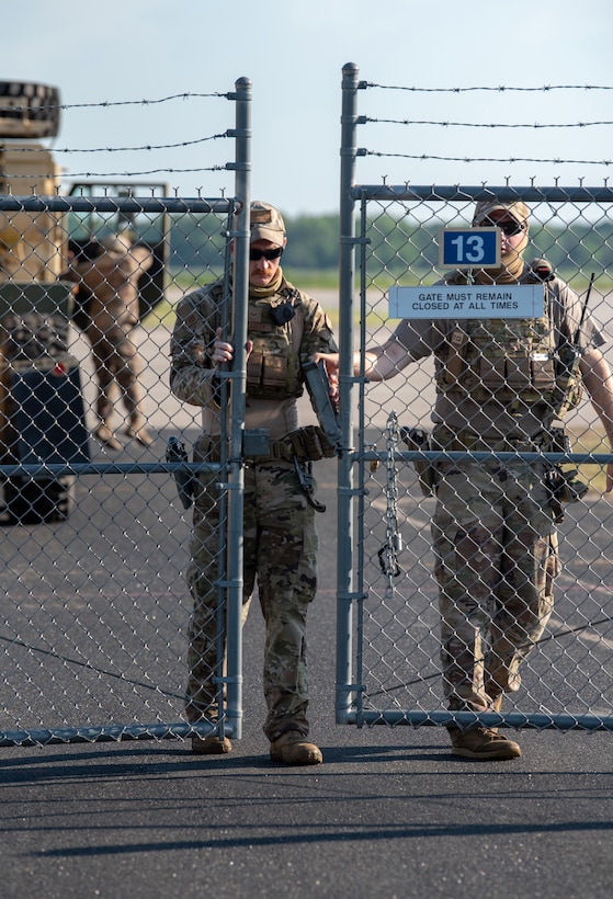 Senior Airman Tyler McCauley and Staff Sgt. Chandler Hunter, security forces specialists with the Kentucky Air National Guard’s 123rd Contingency Response Group, secure the gate during a Joint Task Force-Port Opening exercise known as Operation Lone Oak at Volk Field, Wis., June 11, 2021. The objective of the JTF-PO is to establish a complete air logistics hub and surface distribution network. (U.S. Air National Guard photo by Senior Master Sgt. Vicky Spesard)