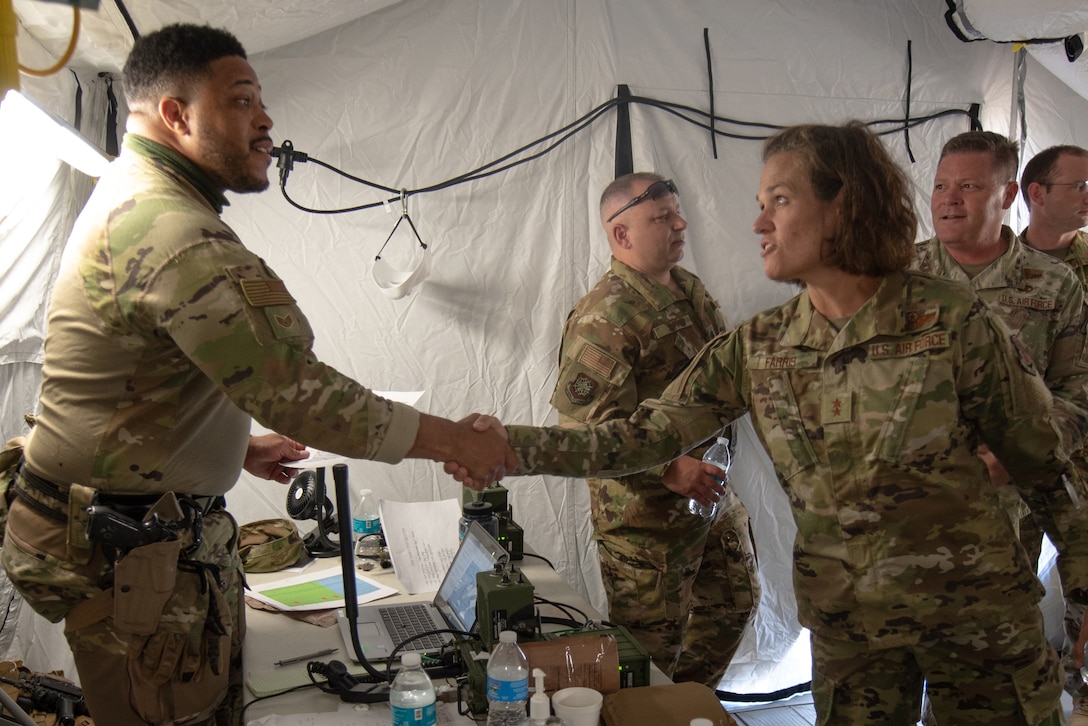 Staff Sgt. Remy Hammock (left), a member of the Kentucky Air National Guard’s 123rd Contingency Response Group, briefs his security forces mission to Maj. Gen. Laurie M. Farris, Air National Guard assistant to the commander, Air Mobility Command, during a Joint Task Force-Port Opening exercise known as Operation Lone Oak at Volk Field, Wis., June 9, 2021. Farris, who is responsible for advising the commander and staff on all air mobility issues impacting the Air National Guard, was familiarizing herself with the JTF-PO exercise, which tasked participants with establishing a complete air logistics hub and surface distribution network. Accompanying the general on the tour was Maj. Gen. James R. Camp (right of Farris), Air National Guard assistant to the commander of United States Transportation Command, and Brig. Gen. Jeffrey Wilkinson (not pictured), Kentucky’s assistant adjutant general for Air. (U.S. Air National Guard photo by Senior Master Sgt. Vicky Spesard)