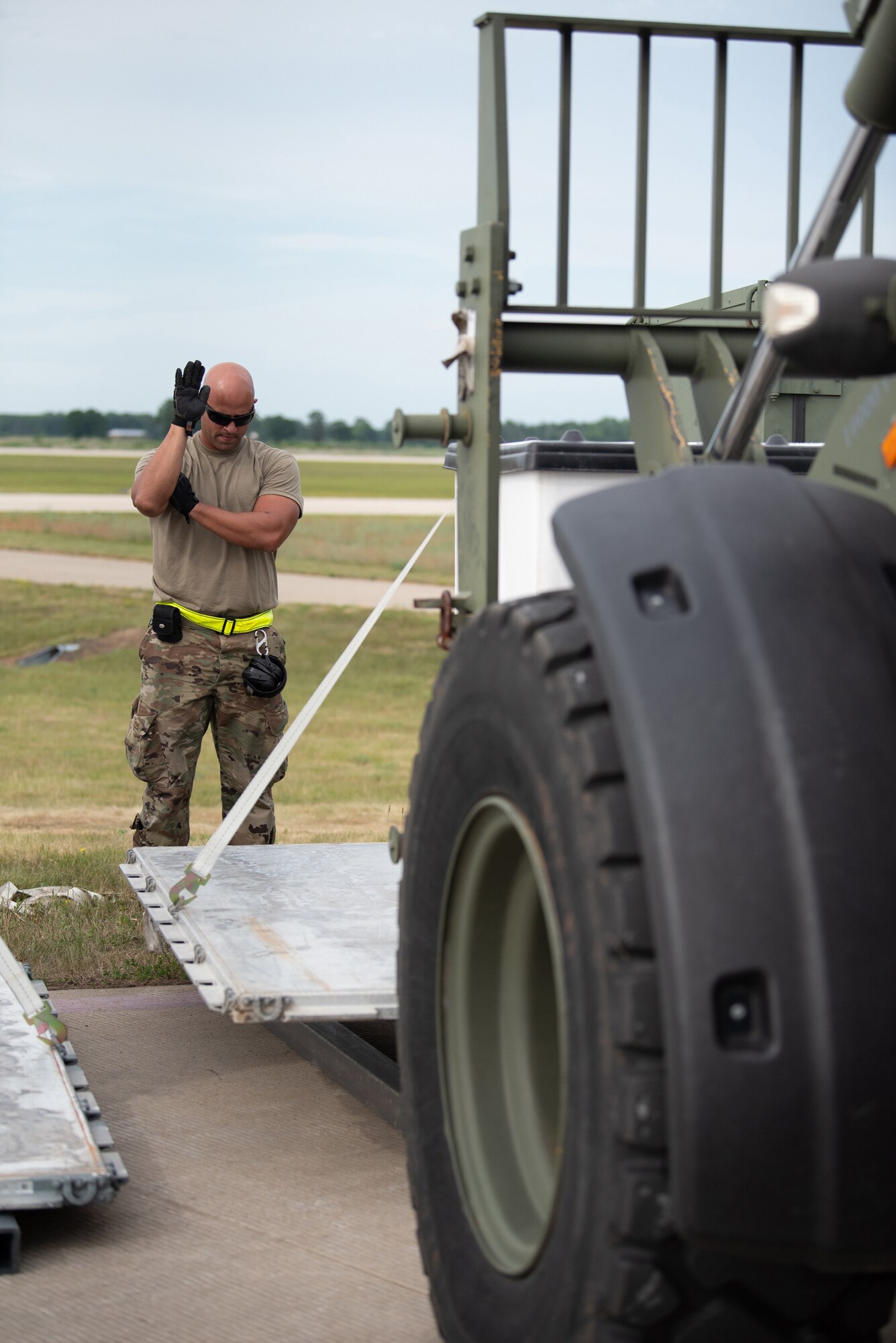 Senior Airman Ricardo Aguilera-Salas, an aerial porter from the Puerto Rico Air National Guard who was augmenting the Kentucky Air National Guard's 123rd Contingency Response Group, guides cargo during Operation Lone Oak at Volk Field, Wis., June 11, 2021. Aerial porters moved cargo 24 hours a day during the exercise. (U.S. Air National Guard photo by Senior Master Sgt. Vicky Spesard)