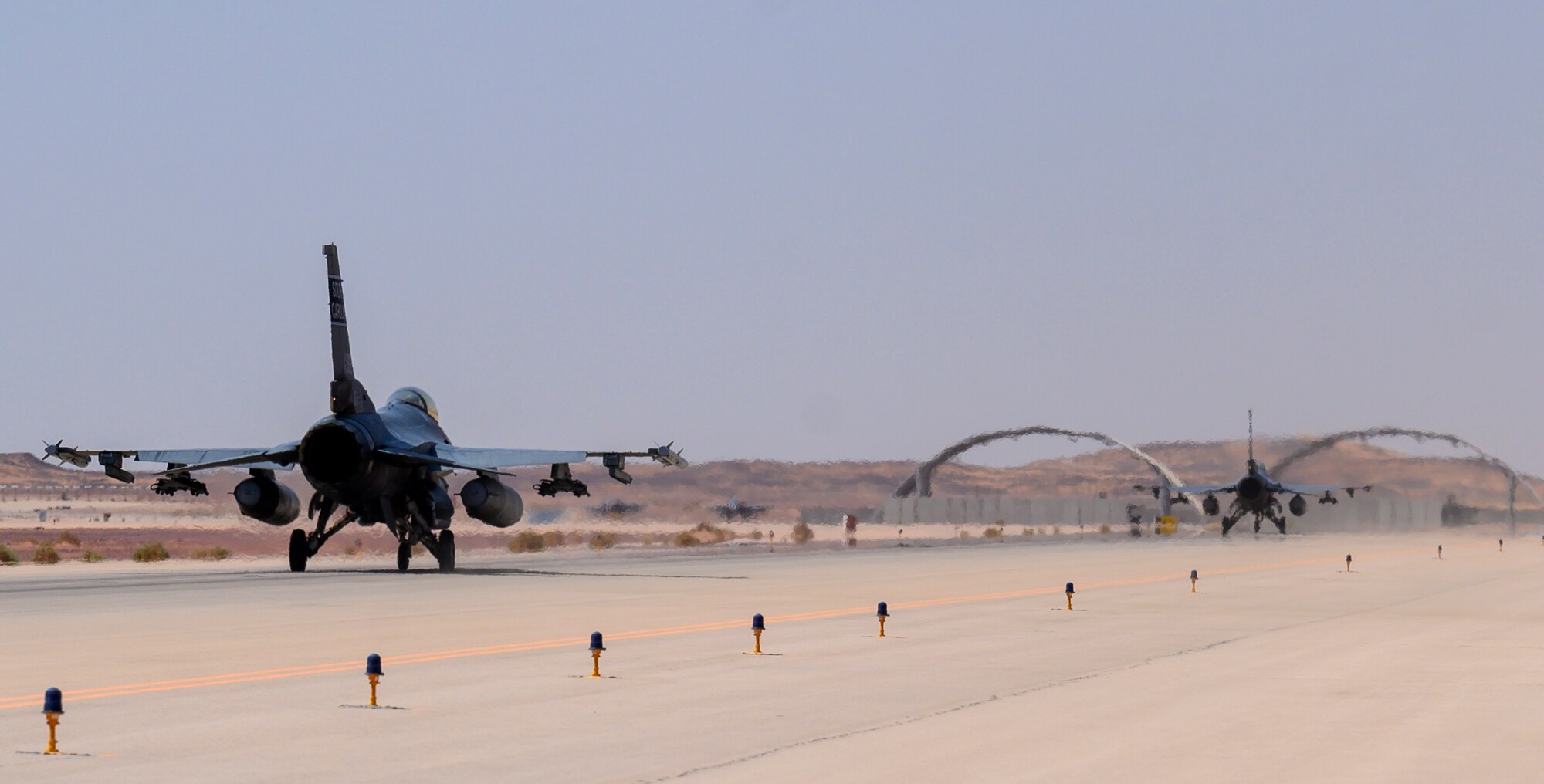 U.S. Air Force Brig. Gen. Robert Davis, 378th Air Expeditionary Wing commander and U.S. Air Force Maj. Taylor Blevins, 157th “Swamp Fox” Expeditionary Fighter Squadron pilot, taxi two U.S. Air Force F-16 Fighting Falcons prior to take-off for a training sortie from Prince Sultan Air Base, Kingdom of Saudi Arabia, June 20, 2021. The 157th EFS is currently deployed to PSAB to bolster defensive capabilities against potential threats in the region. (U.S. Air Force photo by Senior Airman Samuel Earick)