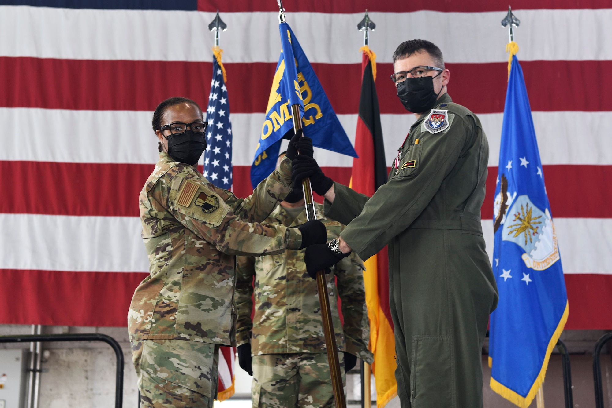 U.S. Air Force Lt. Col. Winton P.D. Laslie, the outgoing 52nd OMRS commander (right), returns the 52nd Operational Medical Readiness Squadron guidon to U.S. Air Force Col. Alisha N. Smith, 52nd Medical Group commander,during the 52nd OMRS change of command ceremony June 18, 2021, on Spangdahlem Air Base, Germany.