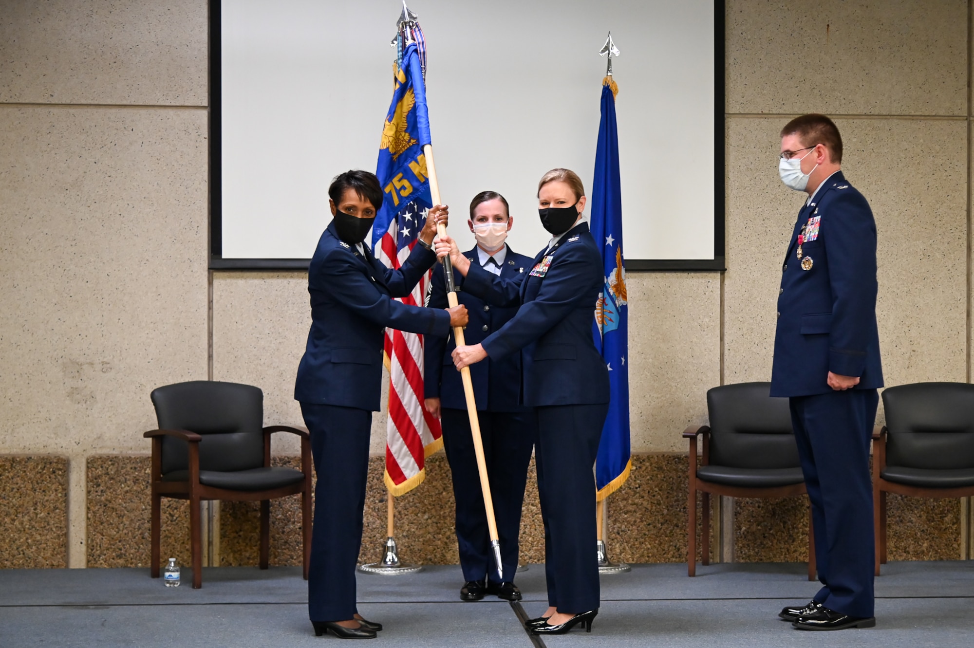 Col. Carroll and Col Swingle pose holding the guidon in between them.