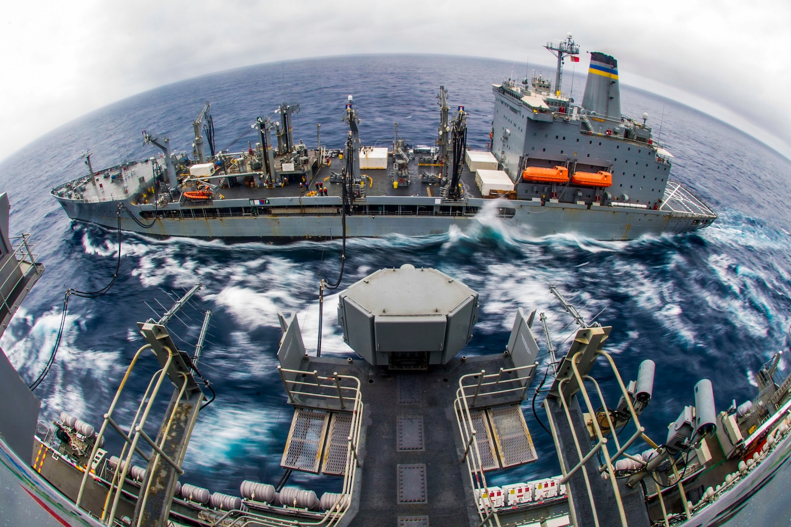 Two ships move together while one delivers fuel to the other.