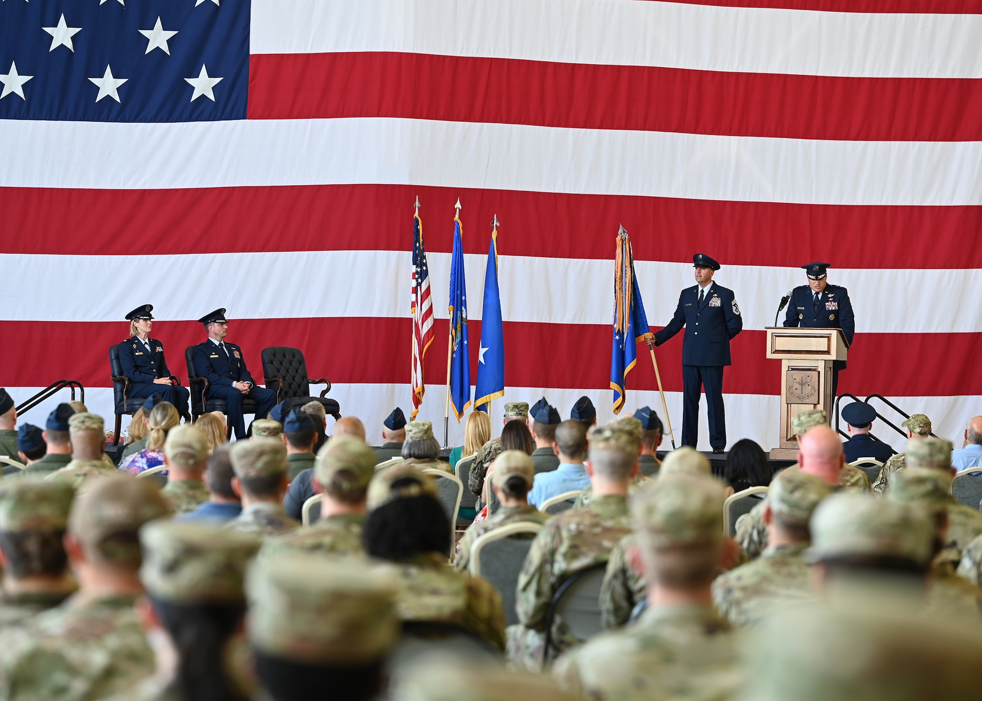 An Airman speaks to attendees during a change of command ceremony.