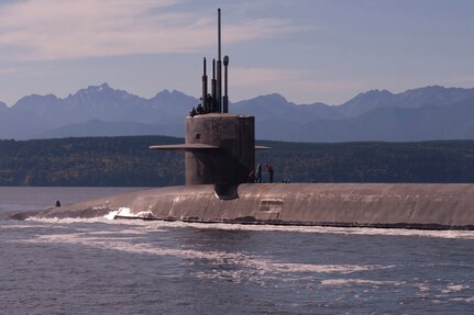 A surfaced submarine moves through the water.