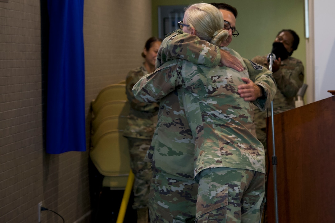 Chief Master Sgt. Justin G. Stoltzfuz, 61st Air Base Group Superintendent, left, hugs Chief Master Sgt. Lisa A. Arnold, Space and Missile Systems Center Command Chief, during an unveiling ceremony for an Enlisted Heritage wall at the South Bay Bar and Grill on Los Angeles Air Force Base, Calif., June 24, 2021. The wall is titled "CMSgt Lisa Arnold Enlisted Heritage Wall" after the current Space and Missile Systems Center's Command Chief Master Sgt. Lisa A. Arnold who will be the last U.S. Air Force command chief for Los Angeles AFB before being replaced by a U.S. Space Force Senior Enlisted Leader. (U.S. Space Force photo by Staff Sgt. Elijah Jackson)