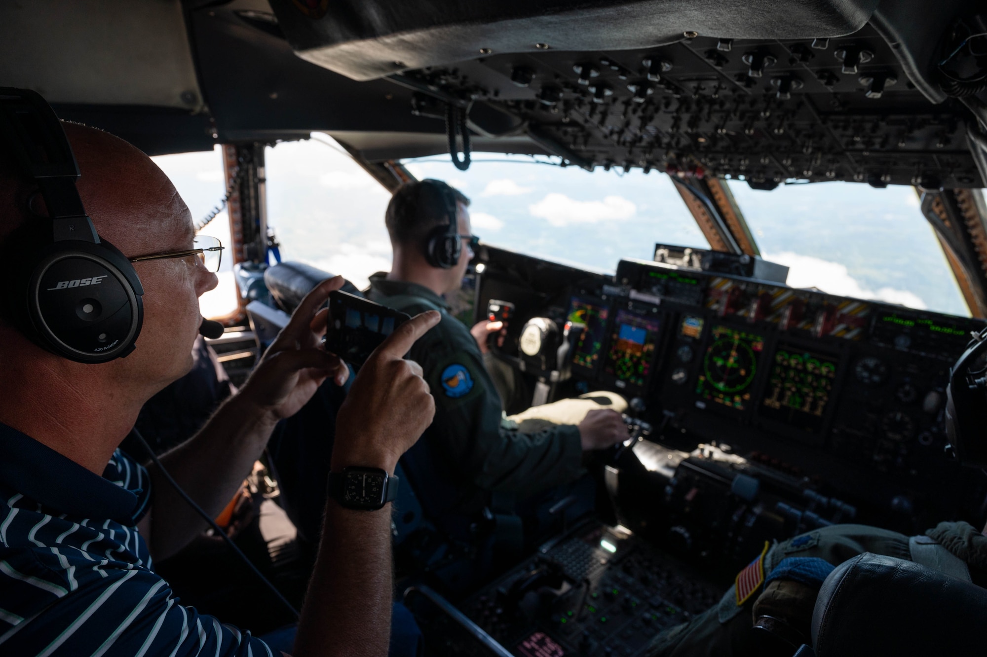 Jason Payne, Dover Air Force Base honorary commander, takes a photo from the jump seat of a C-5M Super Galaxy during an incentive flight at Dover Air Force Base, Delaware, June 23, 2021. The Dover AFB honorary commanders program encourages an exchange of ideas, experiences and friendships between key members of the local community and Dover AFB. (U.S. Air Force photos by Senior Airman Faith Schaefer)