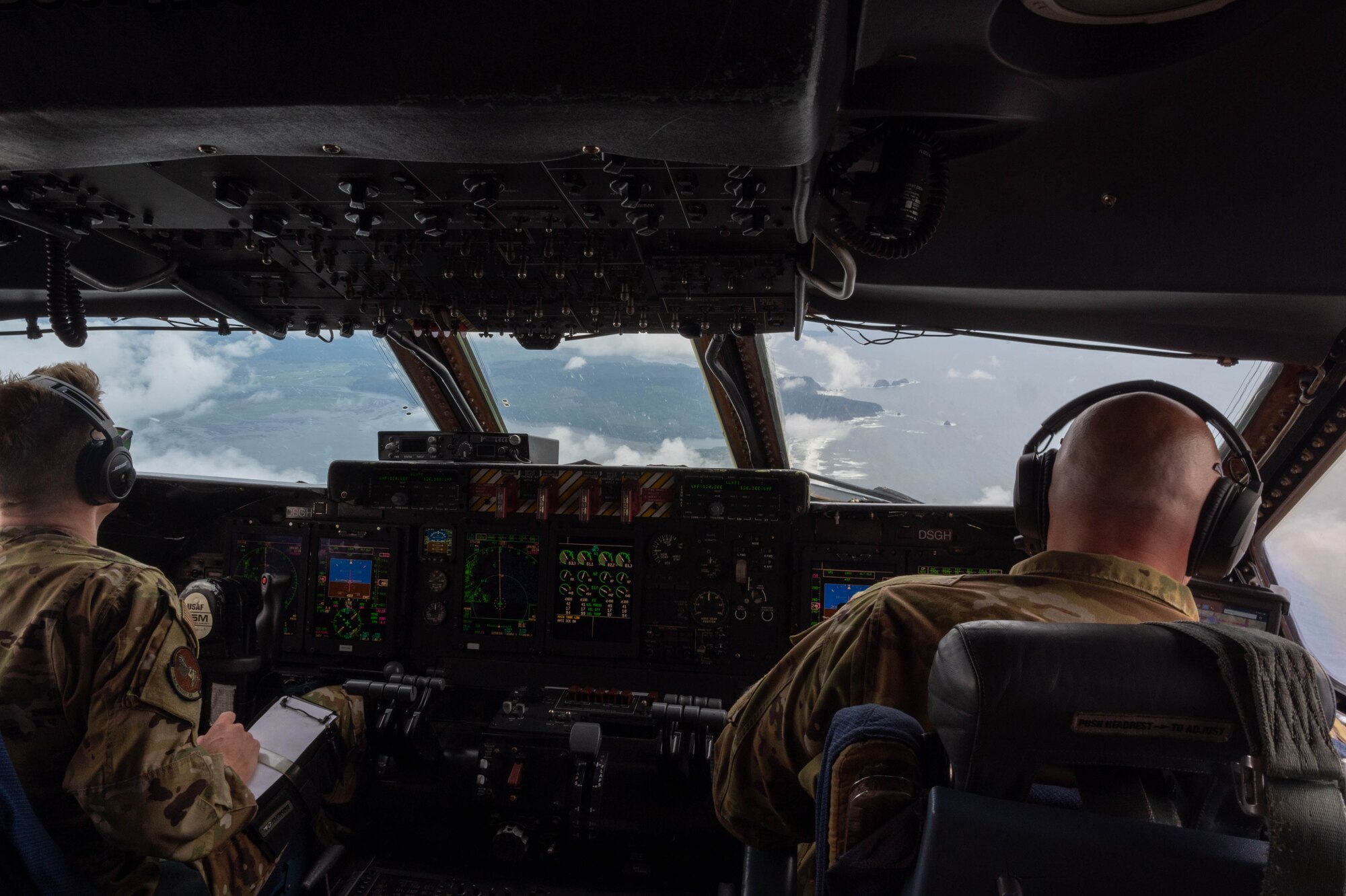 Capt. Shawn Moore, left, and Capt. Dustin Suire, both 9th Airlift Squadron pilots fly a Dover Air Force Base C-5M Super Galaxy on a routine training flight over the Oregon Pacific coast, June 5, 2021. During a Major Command Service Tail Trainer, pilots and flight engineers were able to fly over the West Coast using visual flight rules. This requires crew members to use ground references to fly, exercising different skill sets not often used in day-to-day operations. (U.S. Air Force photo by Senior Airman Faith Schaefer)