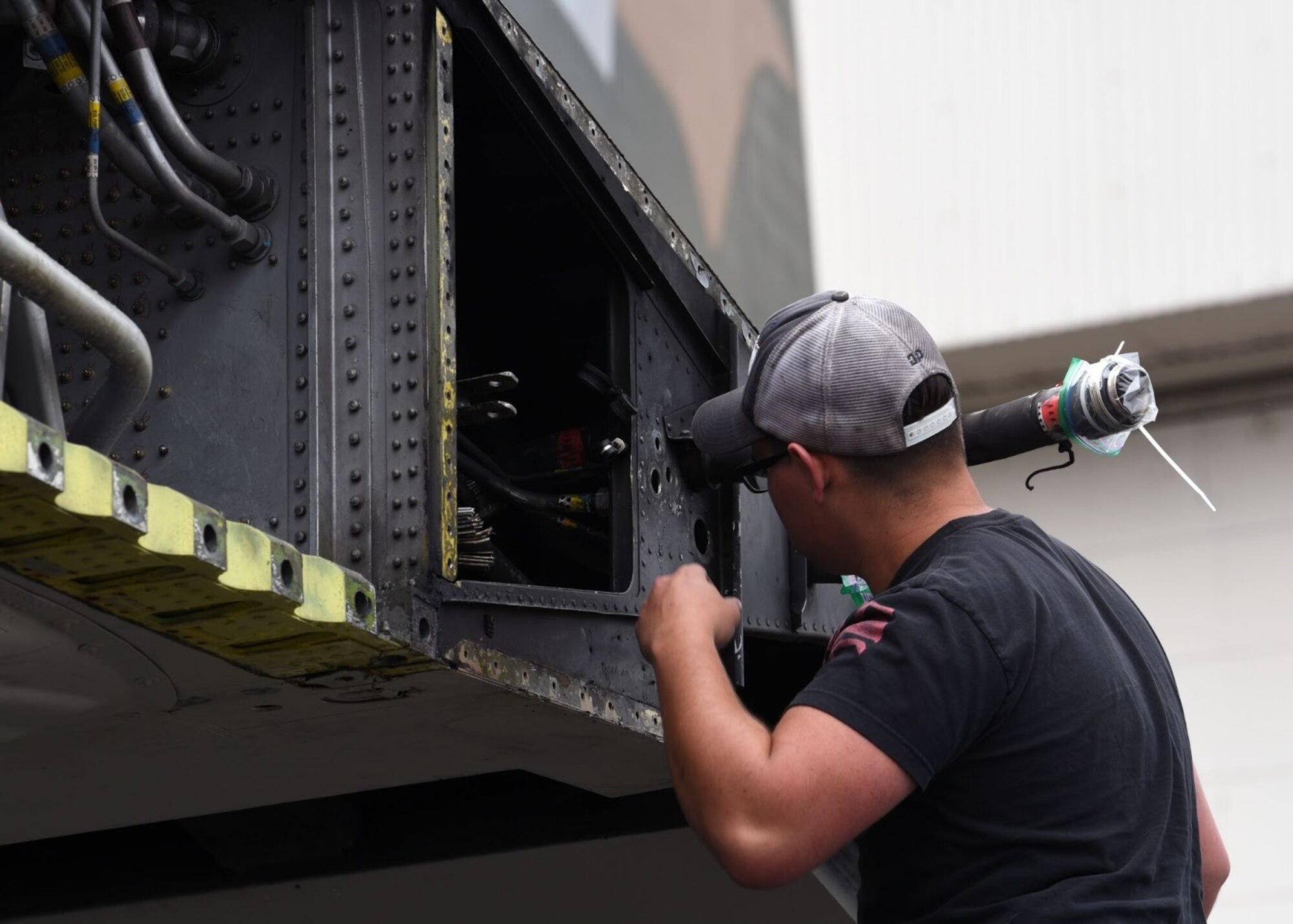 U.S. Air Force Senior Airman Jacob Scott, 62nd Aircraft Maintenance Squadron crew chief, works on a C-130E Hercules at Joint Base Lewis-McChord, Washington, June 13. 2021. The 62nd AMXS worked alongside several other units in order to coordinate and carry out the successful removal of the C-130’s wings, engine, fuel tanks, lower antennas and landing gear doors so the aircraft could be towed down the McChord Field flightline and put on display after restoration. The C-130 was restored by volunteers and will be the newest addition to the aircraft of McChord Air Museum on Heritage Hill. (U.S. Air Force photo by Senior Airman Zoe Thacker)