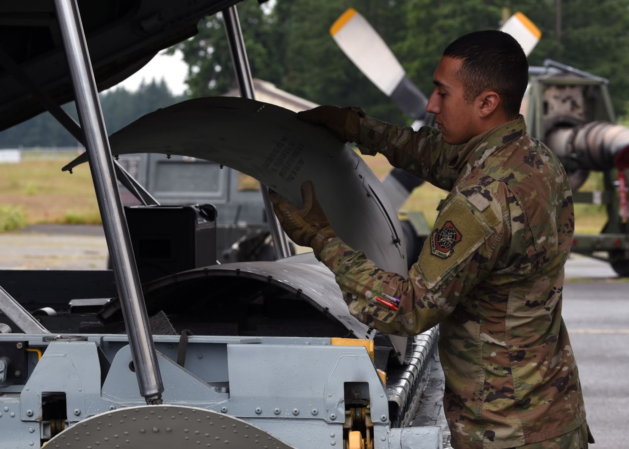 U.S. Air Force Airman Michael Lopez, 62nd Aircraft Maintenance Squadron crew chief, hands pieces of a C-130E Hercules to another Airman at Joint Base Lewis-McChord, Washington, June 12, 2021. The 62nd AMXS worked alongside several other units in order to coordinate and carry out the successful removal of the C-130’s wings, engine, fuel tanks, lower antennas and landing gear doors so the aircraft could be towed down the McChord Field flightline and put on display after restoration. The C-130 was restored by volunteers and will be the newest addition to the aircraft of McChord Air Museum on Heritage Hill. (U.S. Air Force photo by Senior Airman Zoe Thacker)