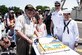 Photo of Naval Support Activity, Lakehurst, centennial attendees cutting a cake.