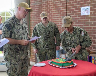 NAVAL STATION NORFOLK (June 25, 2021) Rear Adm. Brendan McLane, the commander of Naval Surface Force Atlantic (SURFLANT), judges a cake from the Arleigh-Burke class guided-missile destroyer USS Oscar Austin (DDG 79) during the final event of SURFLANT Surface Line Week (SLW). An annual competition hosted by Naval Surface Force Atlantic (SURFLANT) for all subordinate SURFLANT commands, SLW sees Hampton Roads-based service members from the Navy and Marine Corps unite to participate in camaraderie-building events and contests. (U.S. Navy photo by Mass Communication Specialist 2nd Class Jacob Milham/Released)