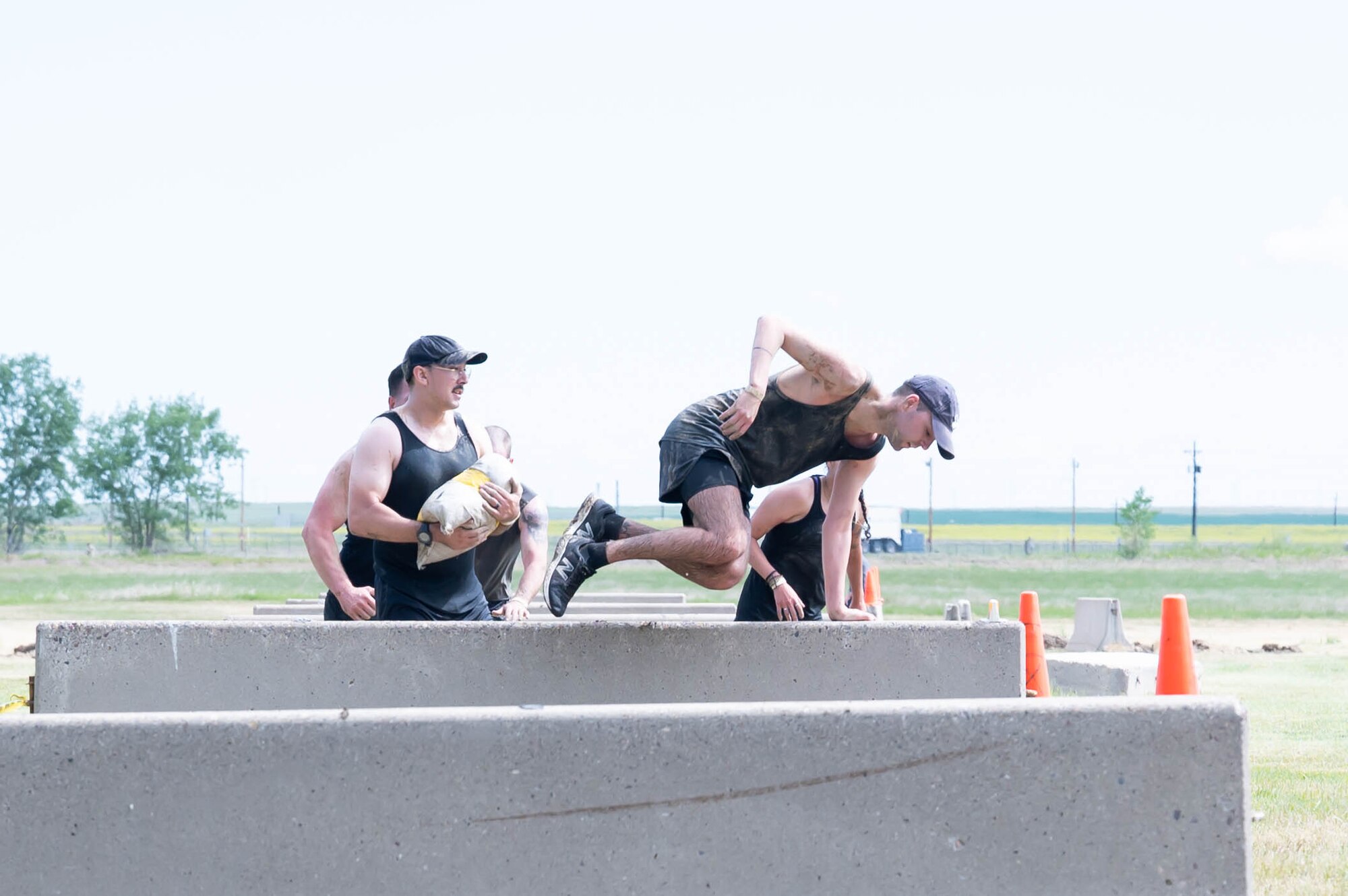 Members of the 341st Missile Wing climb over concrete hurdles during the Filthy Mudder race June 25, 2021, at Malmstrom Air Force Base, Mont.