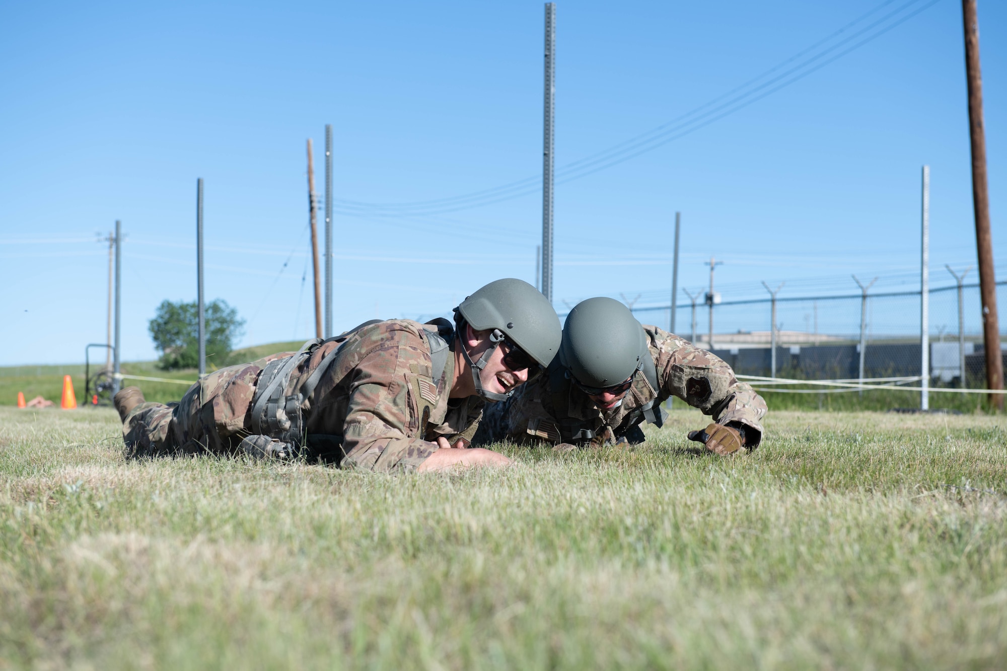 Airmen low-crawl during a battle buddy hill climb competitive event