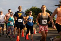 U.S. Marine Corps Col. Speros Koumparakis, commanding officer, Marine Corps Base Hawaii, his wife, and other participants of group three start the race during the annual Surf & Turf 5K, Marine Corps Base Hawaii, June 12, 2021. The annual Surf & Turf 5K aided in the resiliency of service members, their families, and our civilian employees, increasing esprit de corps. (U.S. Marine Corps photo by Lance Cpl. Terry Stennett III)