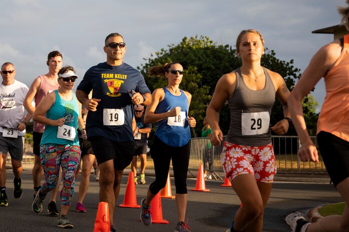 U.S. Marine Corps Col. Speros Koumparakis, commanding officer, Marine Corps Base Hawaii, his wife, and other participants of group three start the race during the annual Surf & Turf 5K, Marine Corps Base Hawaii, June 12, 2021. The annual Surf & Turf 5K aided in the resiliency of service members, their families, and our civilian employees, increasing esprit de corps. (U.S. Marine Corps photo by Lance Cpl. Terry Stennett III)