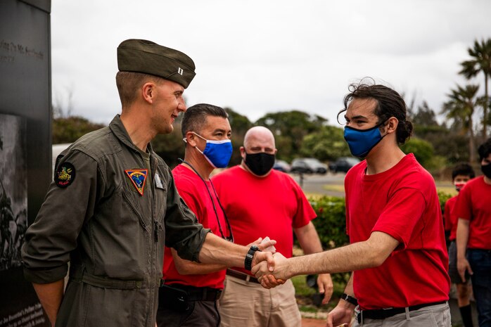 U.S. Marine Corps Capt. Matthew Desrochers, a pilot with Marine Aircraft Group 24, shakes hands with a boy scout from Troop 113 at the end of a community relations event, Marine Corps Base Hawaii, June 17, 2021. MAG 24 hosted the event in an effort to give the boy scouts an opportunity to learn about the world of military aviation. (U.S. Marine Corps photo by Lance Cpl. Brandon Aultman)