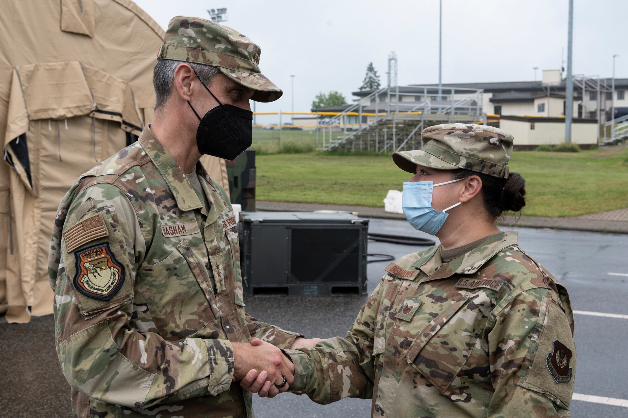 U.S. Air Force Lt. Gen. Steven Basham, U.S. Air Forces in Europe and Air Forces Africa deputy commander, gives a challenge coin to a U.S. Air Force Airman.
