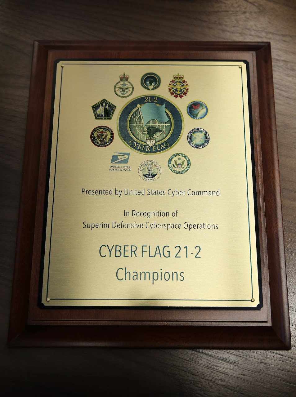 A photo shows a plaque bearing the words Cyber Flag 21-2 champions.