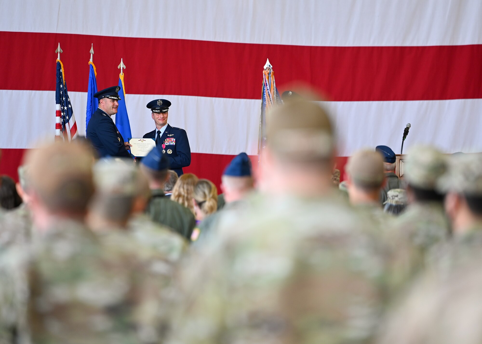Airmen look on as a commander is awarded the Legion of Merit medal during a change of command ceremony.