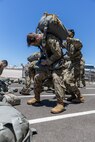 U.S. Army Soldiers with 301st Tactical Psychological Operations, PSYOP, Company (Airborne),14th PSYOP Battalion, 7th PSYOP Group, assist each other with their static-line chutes before performing pre-jump checks during a U.S. Air Force KC-130 Hercules static-line jump exercise at Naval Base Coronado, California, June 11, 2021. The 301st TCP invited I Marine Expeditionary Force Information Group PSYOP Marines to observe jump training before attending the U.S. Army Airborne school. Gaining jump qualifications enables I MIG to effectively integrate and support I Marine Expeditionary Force information operations in forward deployed environments.