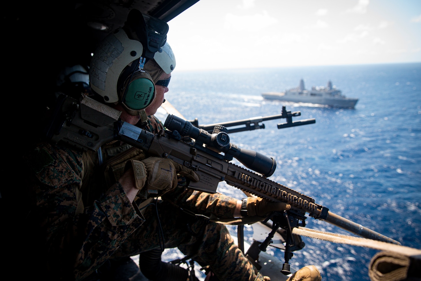 210623-M-TS451-2483 PHILIPPINE SEA - A U.S. Marine with Force Reconnaissance Platoon, 31st Marine Expeditionary Unit (MEU), observes the Philippine Sea while in route to the USS Germantown (LSD 42) to conduct a Maritime Interdiction Operation (MIO) training exercise June 24, 2021. The MIO consisted of Force Reconnaissance Marines fast roping on to the USS Germantown and executing a search and seizure scenario with support from the Battalion Landing Team 3/5 as the security element. The 31st MEU is operating aboard ships of the America Amphibious Ready Group in the 7th fleet area of operation to enhance interoperability with allies and partners and serve as a ready response force to defend peace and stability in the Indo-Pacific region. (U.S. Marine Corps photo by Cpl. Karis Mattingly)