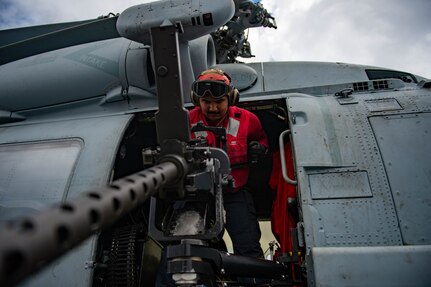 Aviation Ordnanceman 3rd Class Samuel Garcia, from Berwyn, Illinois, prepares a .50-caliber gun mount on an MH-60R Sea Hawk helicopter, attached to the "Proud Warriors" of Helicopter Maritime Strike Squadron (HSM) 72, on the flight deck of the Nimitz-class aircraft carrier USS Harry S. Truman (CVN 75) during Group Sail.