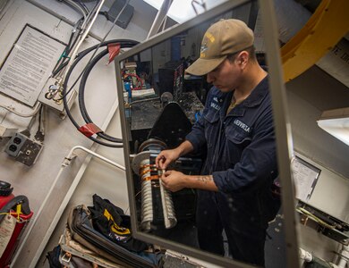 Electricians Mate Fireman Gilberto Diaz, from Los Angeles, uses a coil-winding machine to rewind pole phase groups in the motor rewind shop aboard the Nimitz-class aircraft carrier USS Harry S. Truman (CVN 75) during Group Sail.