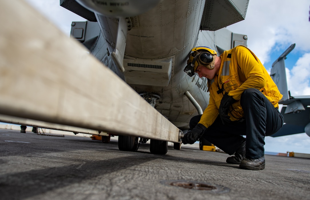 Aviation Boatswain's Mate (Handling) 1st Class Jeffrey Hayes, from Aurora, Colorado, checks a fastener on a tow arm beneath an MH-60R Seahawk helicopter, attached to the "Pround Warriors" of Helicopter Maritime Strike Squadron (HSM) 72, on the flight deck of the Nimitz-class aircraft carrier USS Harry S. Truman (CVN 75) during Group Sail.