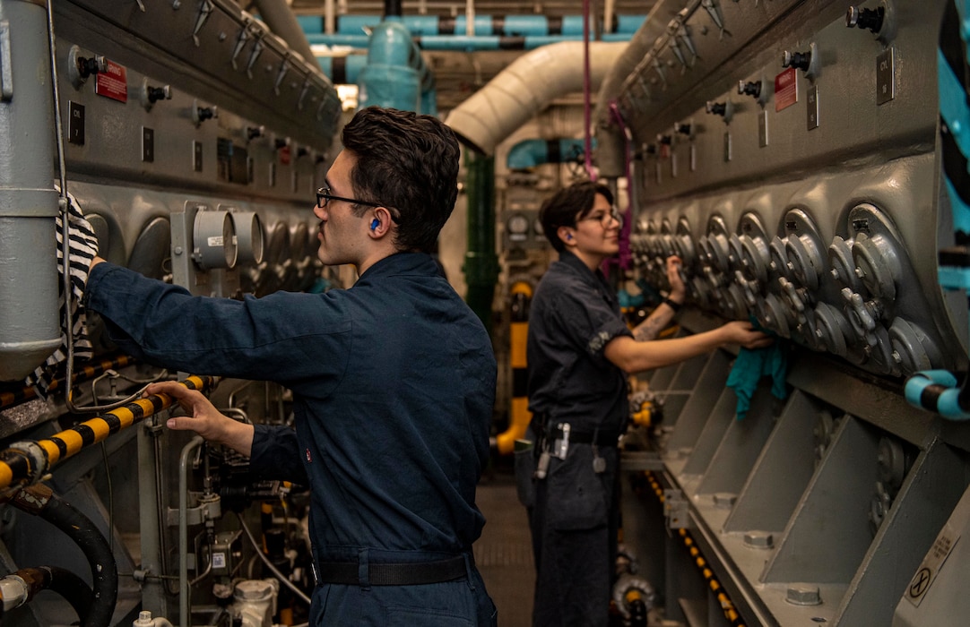 Engineman 3rd Class Benjamyn Corovado, left, and Machinist Mate 2nd Class Olivia Padloff, both from San Diego, wipe down an emergency diesel generator in an emergency diesel room aboard the Nimitz-class aircraft carrier USS Harry S. Truman (CVN 75) during Group Sail.