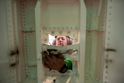 Aviation Machinist Mate 2nd Class Darrin Williams, from Pensacola, Florida, uses corrosion preventative compound to lubricate the dog bone handle of an F/A-18E Super Hornet, attached to the "Blue Blasters" of Strike Fighter Squadron (VFA) 34, in the hangar bay of the Nimitz-class aircraft carrier USS Harry S. Truman (CVN 75) during Group Sail.