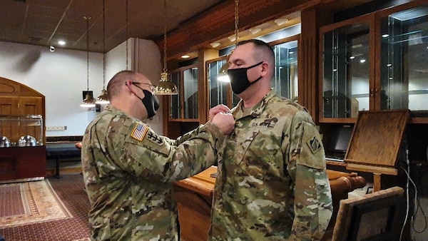 Far East District Commander, COL Christopher Crary, presents SSG Timothy Sepkoski, Southern Resident Office Quality Assurance Rep, with an end-of-service award. Upon separation from the Army, Sepkoski will join SRO as a Civilian.