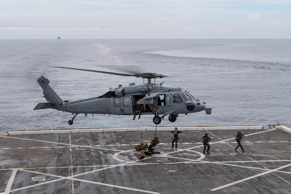 210614-N-XB010-1015 EAST CHINA SEA (June 14, 2021) Marines attached to the 31st Marine Expeditionary Unit (MEU) fast rope from a Marine Corps MH-60S: Sea Hawk from the 31st MEU on USS New Orleans’s (LPD 18) flight deck during a Maritime Raid Force training evolution with USS Germantown (LSD 42). New Orleans, part of the America Amphibious Ready Group, along with the 31st Marine Expeditionary Unit, is operating in the U.S. 7th Fleet area of responsibility to enhance interoperability with allies and partners and serve as a ready response force to defend peace and stability in the Indo-Pacific region. (U.S. Navy photo by Mass Communication Specialist 2nd Class Desmond Parks)