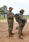 U.S. Army Reserve Col. Kevin M. Myers, G3 operations and jumpmaster for the U.S. Army Civil Affairs and Psychological Operations Command (Airborne), conducts Jumpmaster Personnel Inspection (JMPI) for Maj. Emily R. McElroy, chief of military justice for USACAPOC(A), in preparation for nontactical airborne operations, June 5, 2021, at Saint Mere Eglise drop zone, Fort Bragg, N.C. USACAPOC(A) jumpmasters worked with Capt. Ignacio Rios, a Chilean jumpmaster assigned to the 1st Special Warfare Training Group(A), U.S. Army John F. Kennedy Special Warfare Center and School (USAJFKSWCS). Paratroopers jumping during the airborne operations were eligible to earn foreign wings.