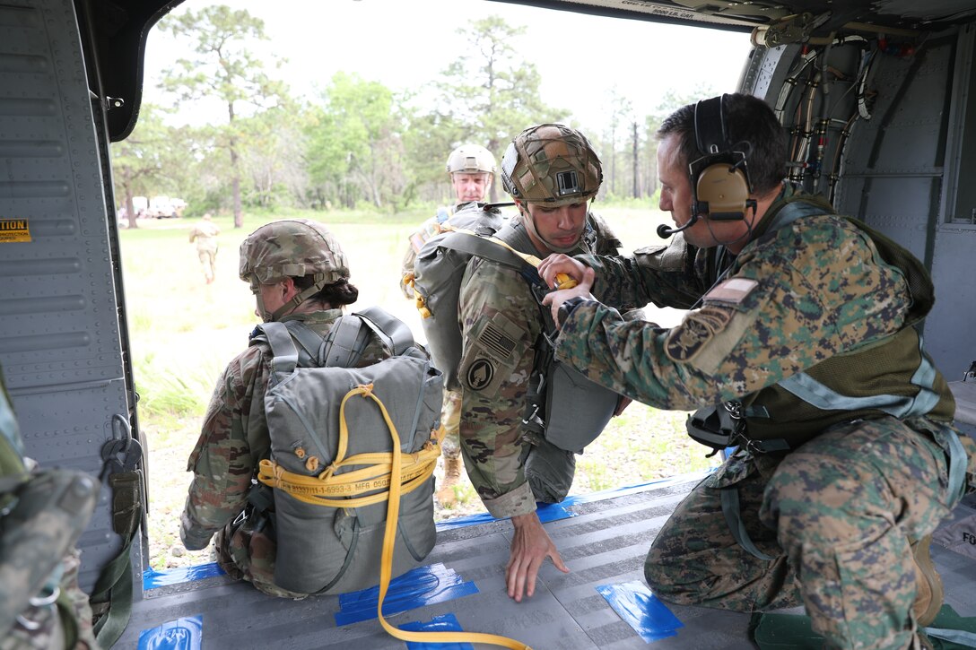 U.S. Army Reserve paratroopers prepare for nontactical airborne operations, June 5, 2021, at Saint Mere Eglise drop zone, Fort Bragg, N.C. USACAPOC(A) jumpmasters worked with Capt. Ignacio Rios, a Chilean jumpmaster assigned to the 1st Special Warfare Training Group(A), U.S. Army John F. Kennedy Special Warfare Center and School (USAJFKSWCS). Paratroopers jumping during the airborne operations were eligible to earn foreign wings.