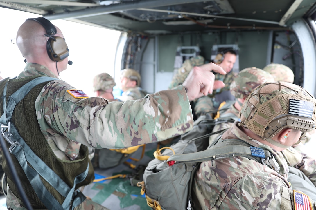 U.S. Army Reserve Lt. Col. Stephen M. Cowne, Jr., G33 and jumpmaster for the U.S. Army Civil Affairs and Psychological Operations Command (Airborne), and Capt. Ignacio Rios, a Chilean jumpmaster assigned to the 1st Special Warfare Training Group(A), U.S. Army John F. Kennedy Special Warfare Center and School (USAJFKSWCS) signal in preparation for nontactical airborne operations, June 5, 2021, at Saint Mere Eglise drop zone, Fort Bragg, N.C. Paratroopers jumping during the airborne operations were eligible to earn foreign wings.