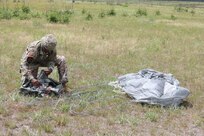 U.S. Army Reserve Master Sgt. Folarin L. Durosawo, assistant Inspector General for the U.S. Army Civil Affairs and Psychological Operations Command (Airborne), collects his parachute to bring back to a consolidated collection point during nontactical airborne operations at Saint Mere Eglise drop zone, Fort Bragg, N.C., June 5, 2021. USACAPOC(A) jumpmasters worked with Capt. Ignacio Rios, a Chilean jumpmaster assigned to the 1st Special Warfare Training Group(A), U.S. Army John F. Kennedy Special Warfare Center and School (USAJFKSWCS). Paratroopers jumping during the airborne operations were eligible to earn foreign wings.