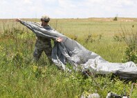U.S. Army Reserve Maj. Paul F. Arentz, staff judge advocate with the U.S. Army Civil Affairs and Psychological Operations Command (Airborne), collects his parachute to bring back to a consolidated collection point during nontactical airborne operations at Saint Mere Eglise drop zone, Fort Bragg, N.C., June 5, 2021. USACAPOC(A) jumpmasters worked with Capt. Ignacio Rios, a Chilean jumpmaster assigned to the 1st Special Warfare Training Group(A), U.S. Army John F. Kennedy Special Warfare Center and School (USAJFKSWCS). Paratroopers jumping during the airborne operations were eligible to earn foreign wings.