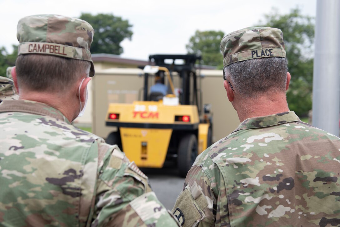 Maj. Gen. Michael Place, 18th Medical Command (Deployment Support) commanding general, right, and Col. Dane Campbell, 374th Medical Group Commander, observe part of a medical exercise at Yokota Air Base, Japan, June 24, 2021. Place came to Yokota to talk about various aspects of how the base supports the deployment of medical supplies and to observe the buildup of a mobile hospital. (U.S. Air Force photo by Staff Sgt. Joshua Edwards)