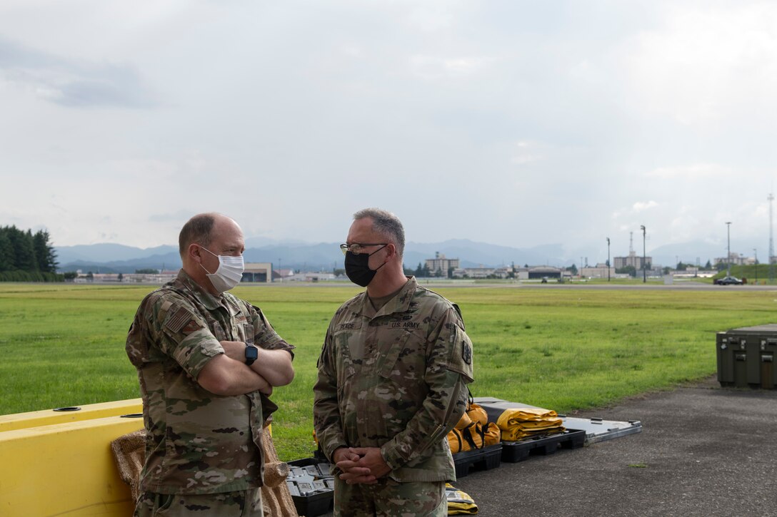 Maj. Gen. Michael Place, 18th Medical Command (Deployment Support) commanding general, right, and Col. Dane Campbell, 374th Medical Group Commander, view the loading area of the War Reserve Materiel warehouse at Yokota Air Base, Japan, June 24, 2021. Place spoke with leadership and medical professionals at Yokota on how to utilize resources in a joint deployed area. (U.S. Air Force photo by Staff Sgt. Joshua Edwards)