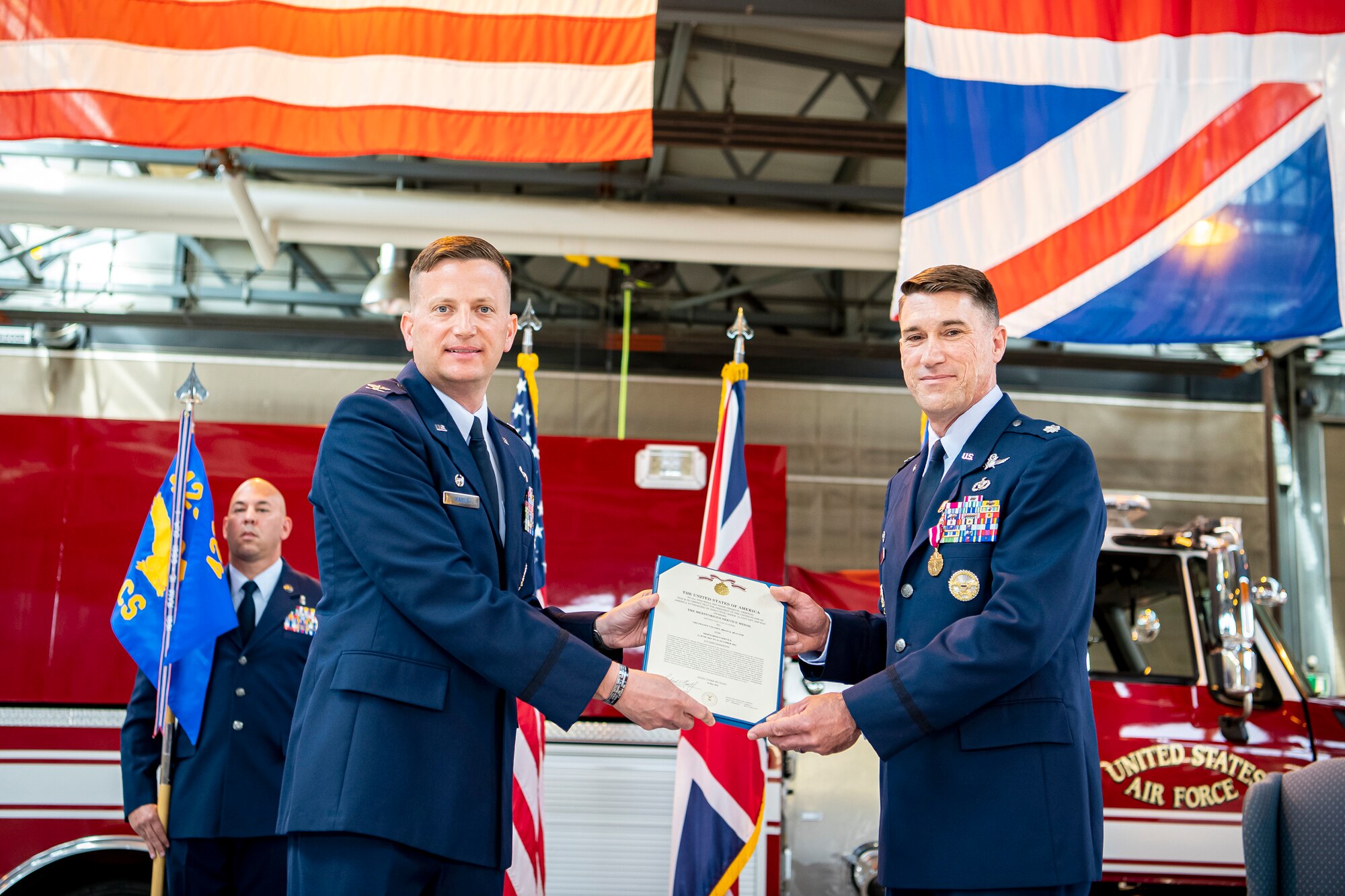 U.S. Air Force Col. Richard Martin, left, 423rd Air Base Group commander, presents a Meritorious Service Medal to Lt. Col. Brian Beauter, 423rd Communications Squadron outgoing commander, during a change of command ceremony at RAF Alconbury, England, June 25, 2021. During the ceremony, Beauter relinquished command of the 423rd CS to Maj. Erica Balfour. (U.S. Air Force photo by Senior Airman Eugene Oliver)