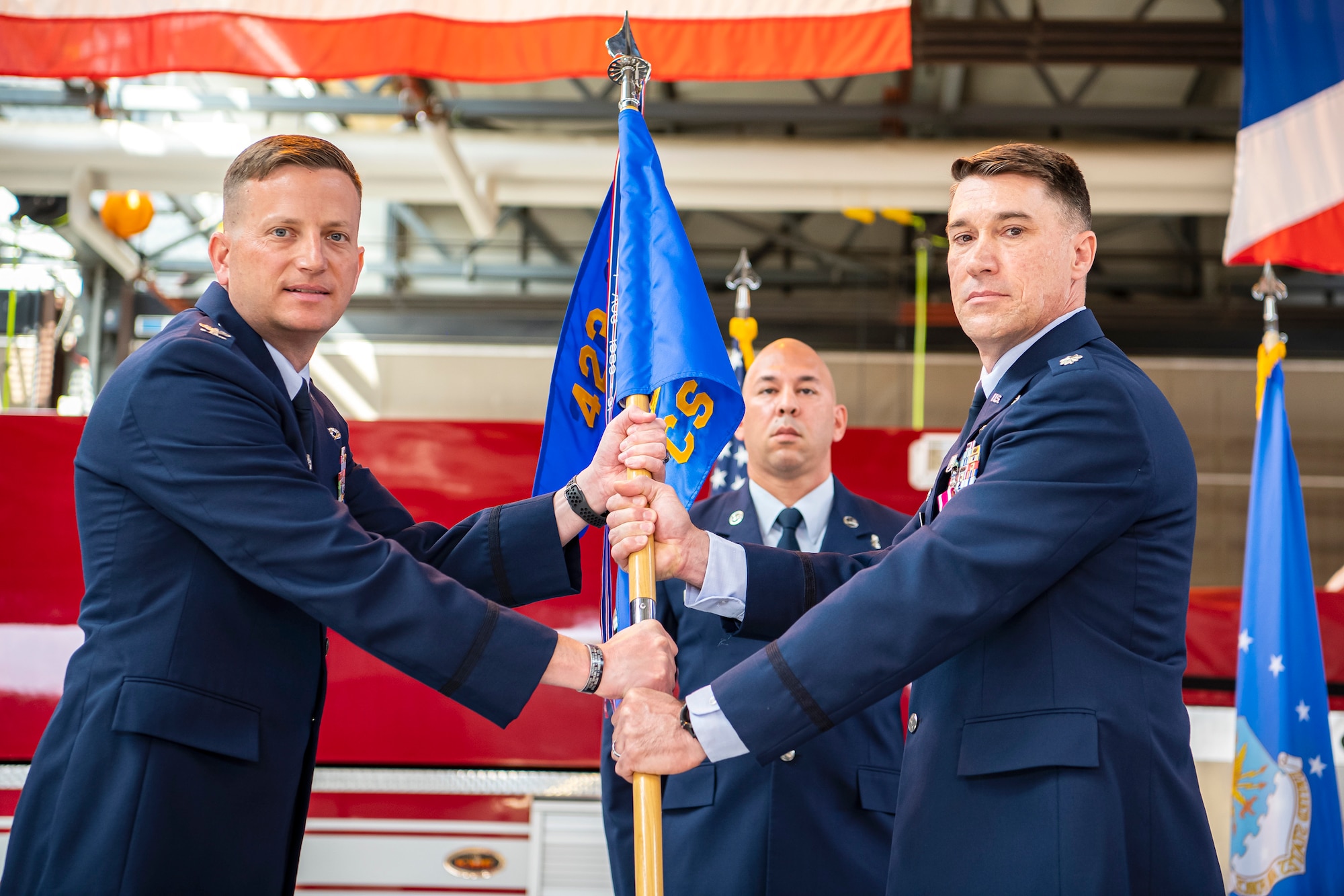 U.S. Air Force Col. Richard Martin, left, 423rd Air Base Group commander, receives the 423rd Communications Squadron guidon from Lt. Col. Brian Beauter, 423rd Communications Squadron outgoing commander, during a change of command ceremony at RAF Alconbury, England, June 25, 2021. The ceremony is a military tradition that represents a formal transfer of a unit’s authority and responsibility from one commander to another. (U.S. Air Force photo by Senior Airman Eugene Oliver)