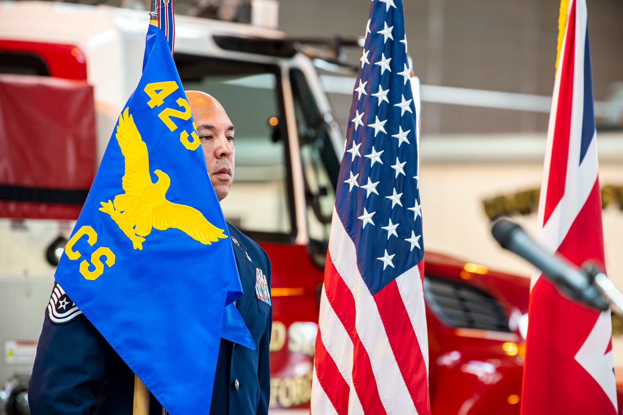 U.S. Air Force Master Sgt. Hector Valasquez-Ramos, 423rd Communications Squadron first sergeant, holds the guidon during a change of command ceremony at RAF Alconbury, England, June 25, 2021. The ceremony is a military tradition that represents a formal transfer of a unit’s authority and responsibility from one commander to another. (U.S. Air Force photo by Senior Airman Eugene Oliver)